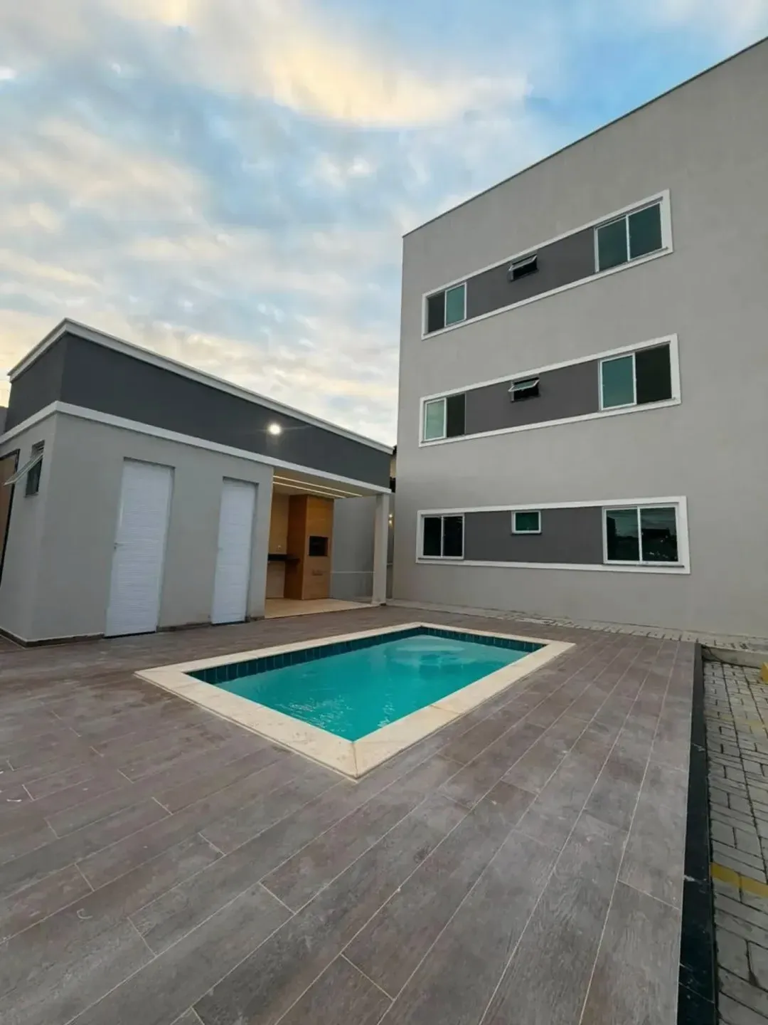 Prédio residencial com piscina ao entardecer